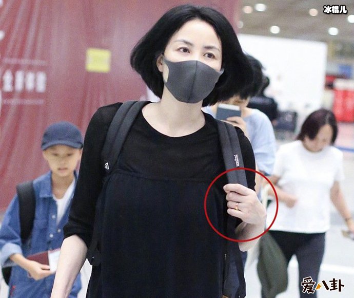 王菲现身机场无名指戒指抢眼